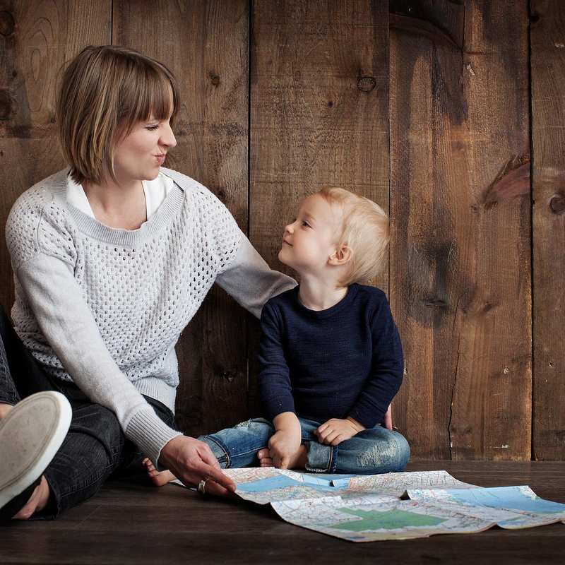 Eine Mutter mit einem kleinen Kind sitzen am Boden. 