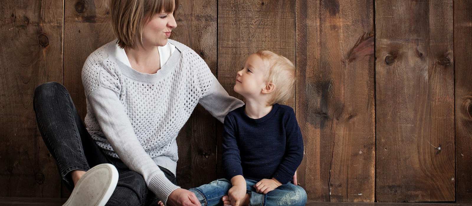 Eine Mutter mit einem kleinen Kind sitzen am Boden. 