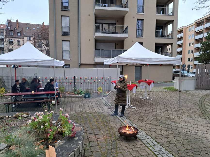 Größer Platz mit Pavillons und Bänken. Pfarrerin Lidia Barth spricht zu den Klienten*innen.