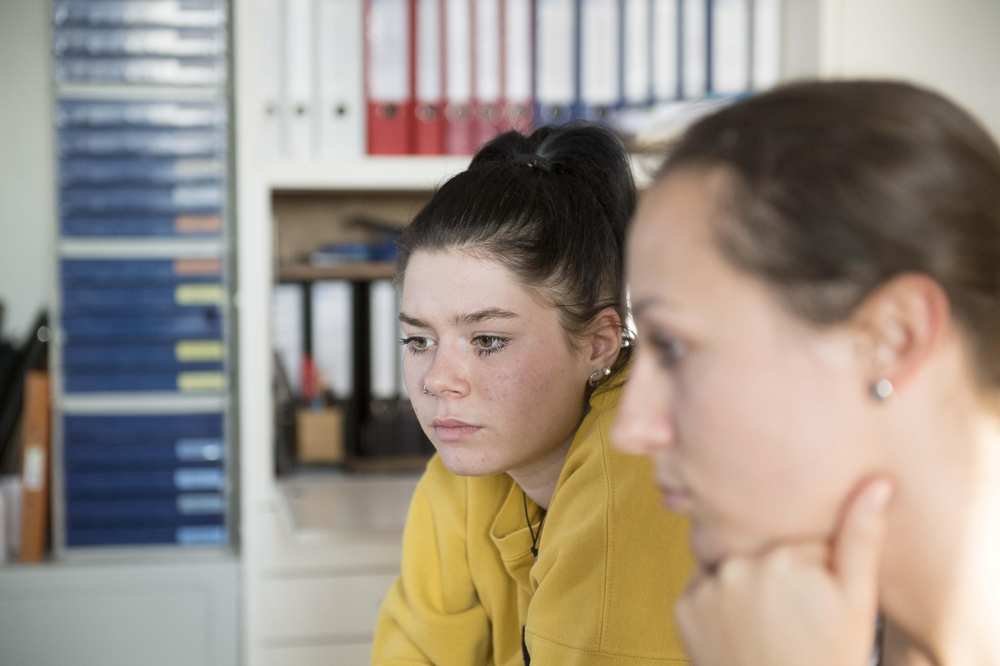 Zwei Frauen sitzen in einem Büro.