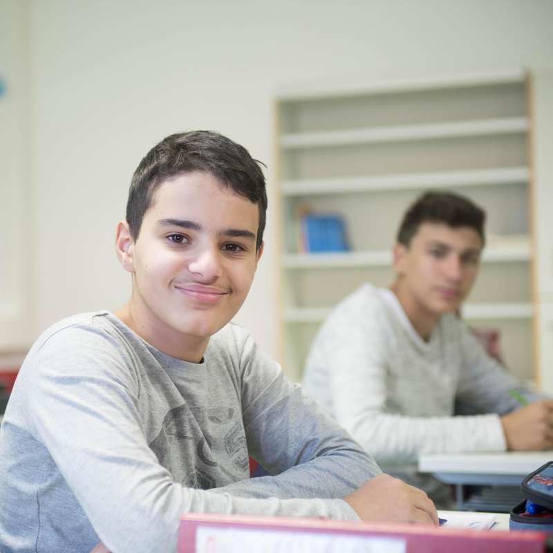 Zwei Jugendliche sitzen im Klassenzimmer.