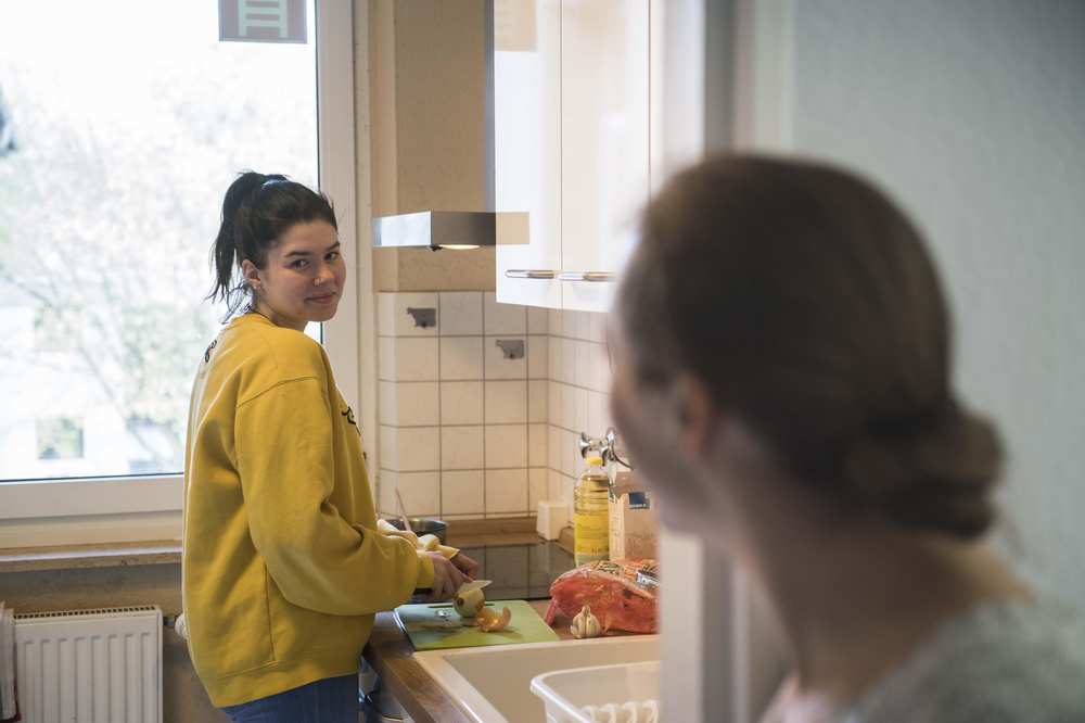 Eine Jugendliche spült Geschirr.