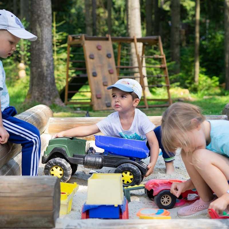 Drei Kinder spielen in einem Sandkasten