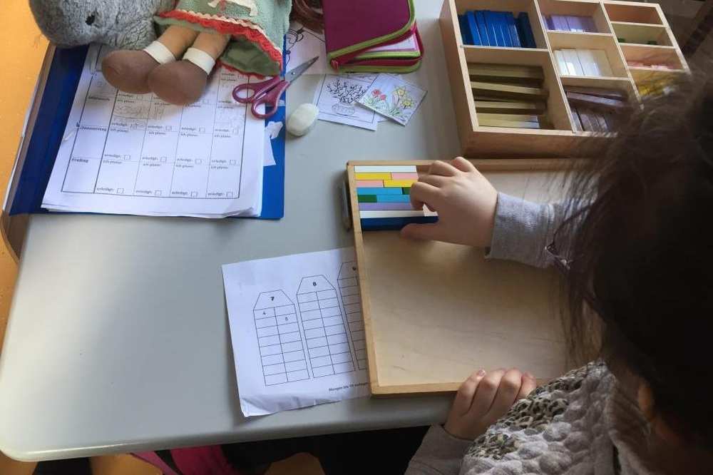 Ein Mädchen sitzt am Schreibtisch und löst Aufgaben.